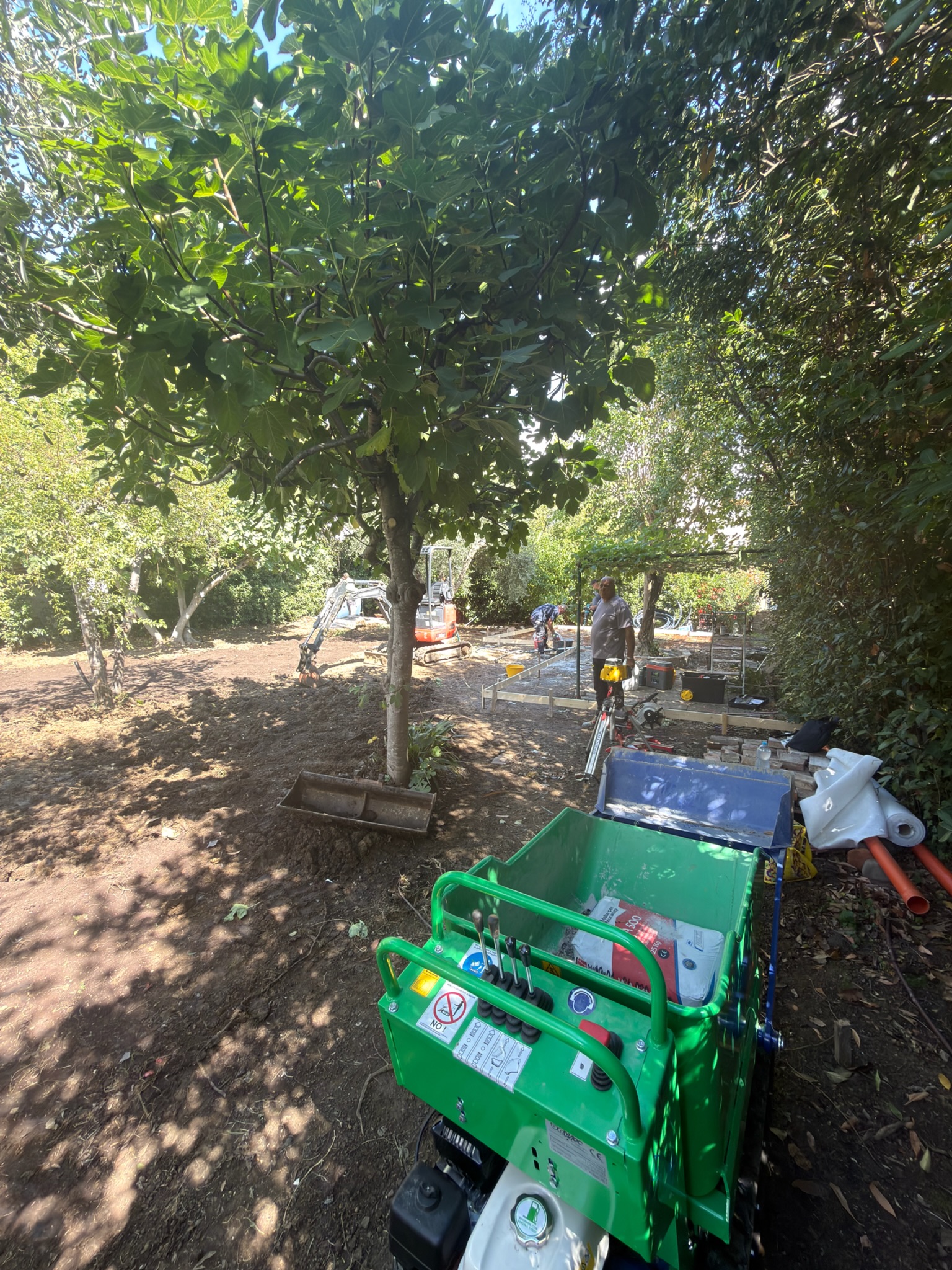 Lavorazioni di sistemazione del terreno con miniescavatore all’interno del giardino.