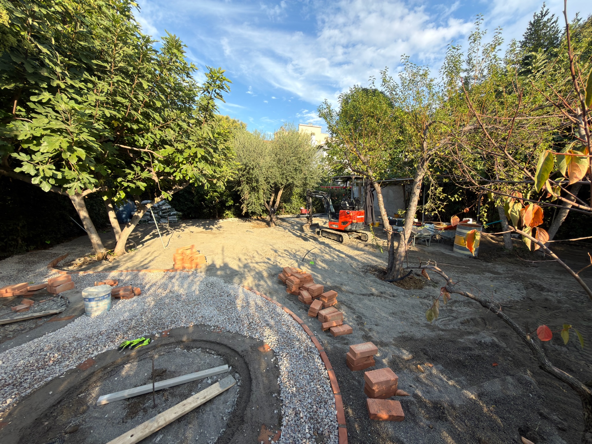 Preparazione di un percorso curvo in giardino con sottofondo in ghiaia e posa delle bordature.